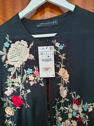 Chaqueta bordada negra con flecos.