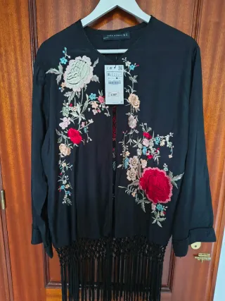 Chaqueta bordada negra con flecos.