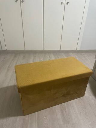 Baúl de tela amarillo, y negro por dentro.