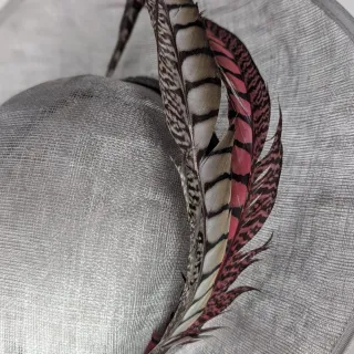 Tocado gris con plumas rosas y marrones