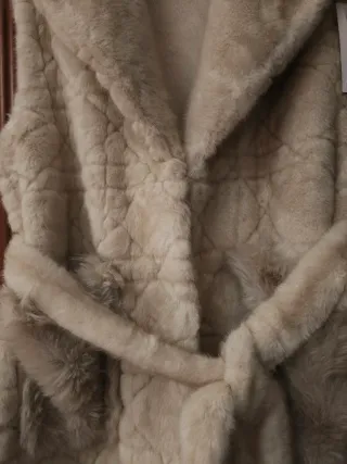 Colete de pêlo fofinho com bolsos e cinto.