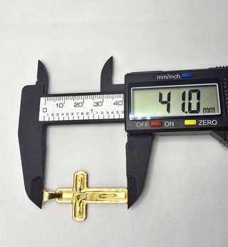 Cruz de oro de 18k. Peso: 4.52 g.