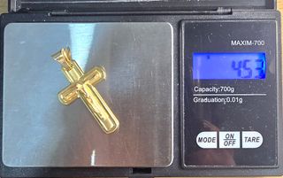 Cruz de oro de 18k. Peso: 4.52 g.