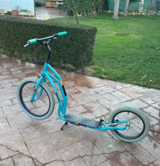 Patinete azul con ruedas grandes