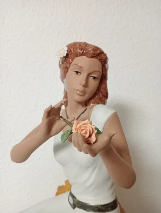 Statuetta natalizia in porcellana di una donna seduta su una pietra