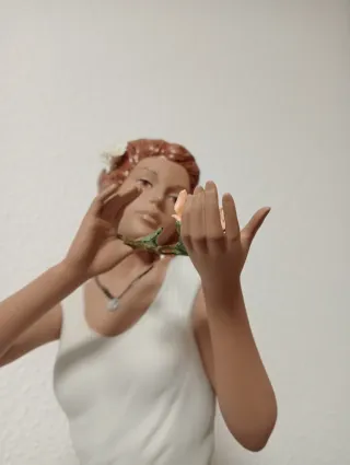 Statuetta natalizia in porcellana di una donna seduta su una pietra