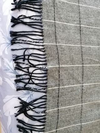 Copriletto grigio a quadri con frange