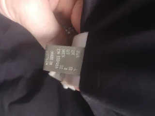 Plumífero negro con capucha y cinturón