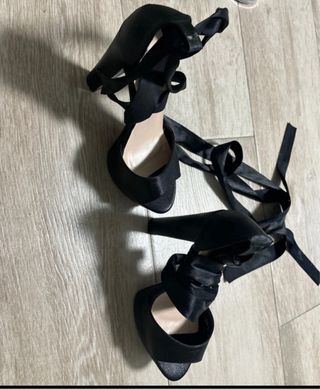 Tacones negros atados a la pierna