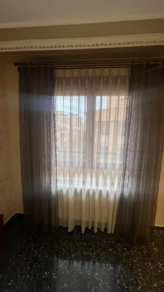 Cortinas de tela beige y marrón con caídas lateral