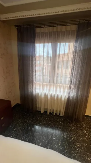 Cortinas de tela beige y marrón con caídas lateral