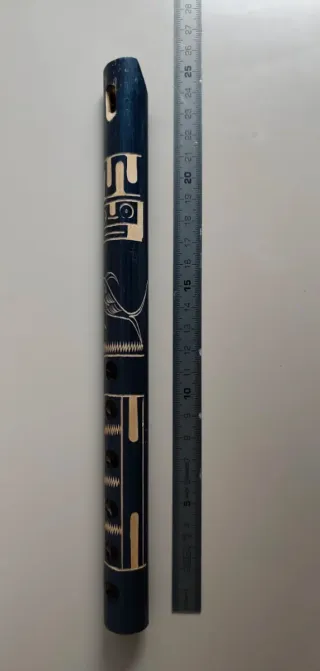 Flauta artesanal azul con grabados.