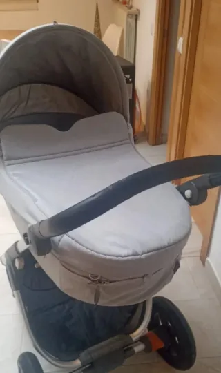 Cochecito Stokke gris con plástico de lluvia