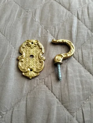 Supporto per tenda in metallo dorato.