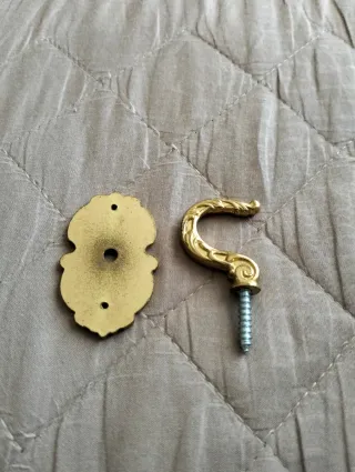 Supporto per tenda in metallo dorato.