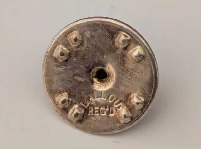 Pin solapa de plata.