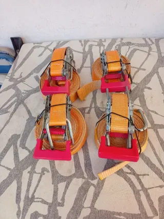 4 eslingas con carraca y gancho color naranja.