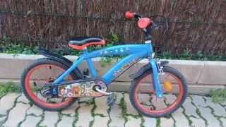 Bicicleta infantil azul con ruedas rojas