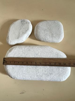 Tre pietre di marmo levigate dal mare
