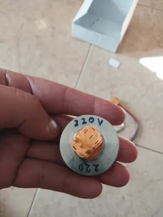 Botón pulsador metálico con símbolo de encendido