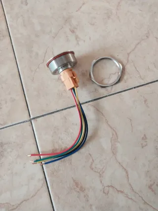 Botón pulsador metálico con símbolo de encendido