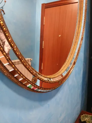 Espejo ovalado dorado con detalles