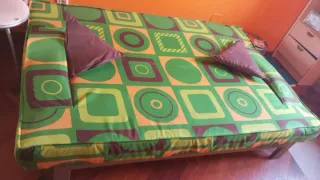 Sofá cama tela verde y naranja reclinable.