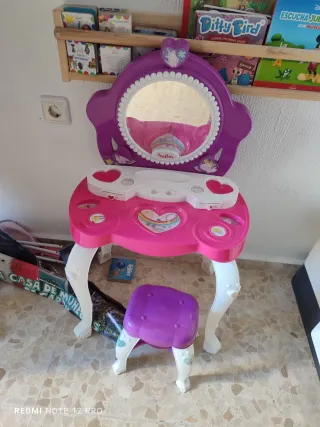 Tocador infantil rosa y morado con taburete.