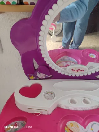 Tocador infantil rosa y morado con taburete.