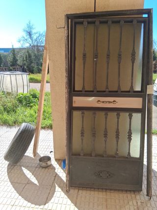Puerta de hierro macizo y metal con reja y cristal