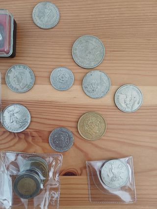 Lote de monedas variadas y lupa