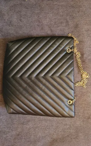 Bolso de mano negro con cadena dorada
