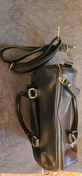Bolso negro con bolsillo delantero efecto pelo.