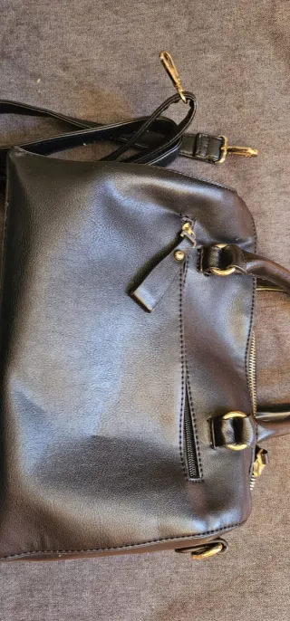 Bolso negro con bolsillo delantero efecto pelo.