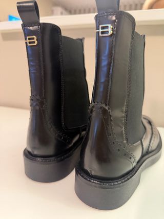 Botins pretos pelo tornozelo