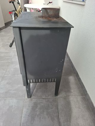 Estufa de leña metálica con puerta de cristal
