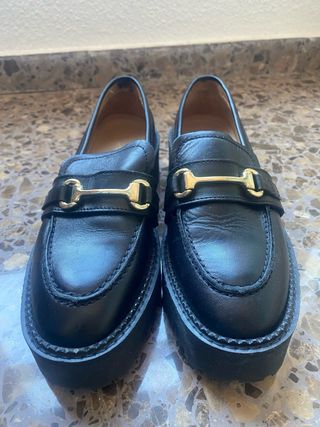 Mocasines negros con hebilla dorada