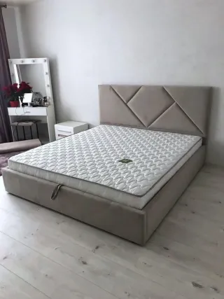 Cama tapizada gris con cabecero
