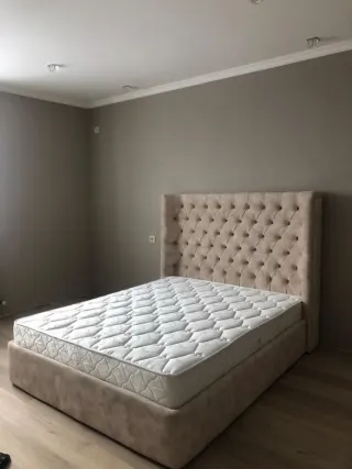 Cama tapizada gris con cabecero