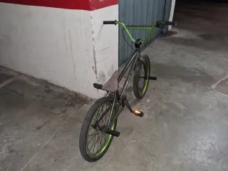 Bicicleta BMX gris con detalles verdes