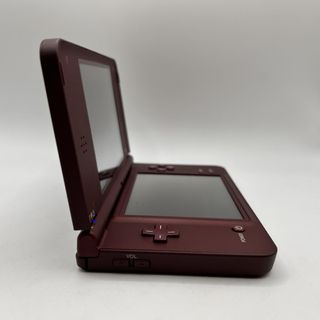 CONSOLA NINTENDO DSI XL GRANATE CON CARGADOR SOMBRA EN PANTALLA