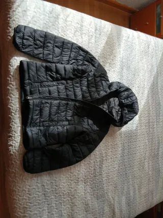 Chaqueta fina acolchada negra con capucha.