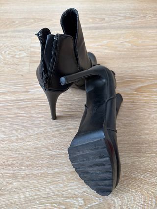 Botines de tacón aguja negros.