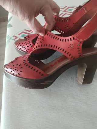 Sandalias rojas de lleva un rascado en un lado