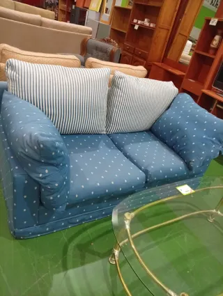 Sofá azul con cojines blancos