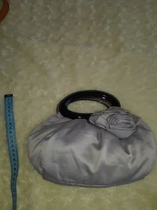 Bolso de mano plateado con flor