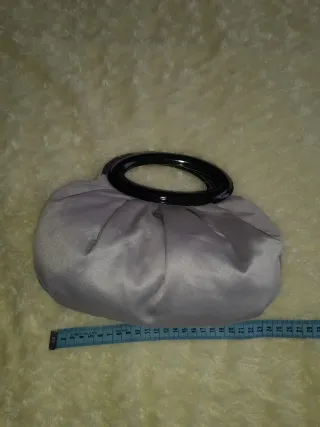 Bolso de mano plateado con flor