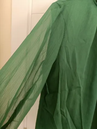 Blusa verde con cuello alto y volantes