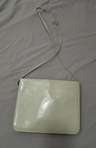 Bolso de piel gris con logo dorado
