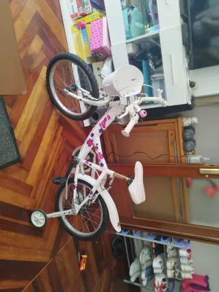 Bicicleta infantil blanca con ruedas de apoyo